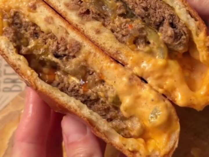 Sealed stuffed burger pocket sliced open showing molten cheese and juicy beef