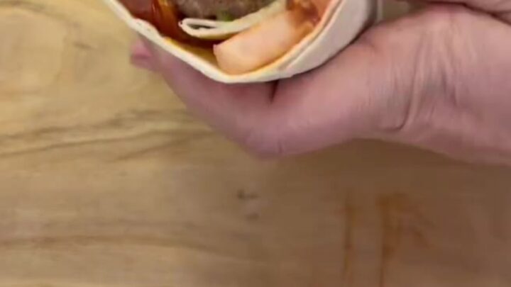 Crispy dürüm wrap sliced in half, showing juicy kebab and sumac onions