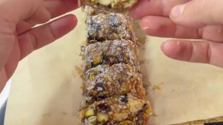 Sliced energy roll medallions showing pistachios and nuts in dark date fudge