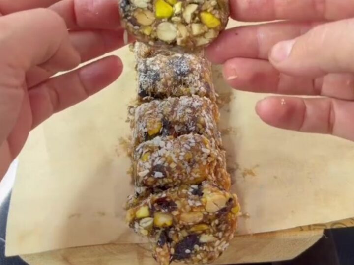 Sliced energy roll medallions showing pistachios and nuts in dark date fudge