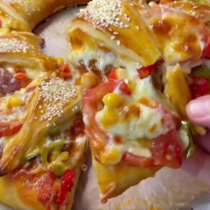 Golden ring pizza with melted cheese and sucuk, sliced to show cheese pull
