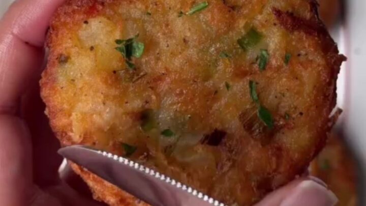 Crispy potato veggie patty being dipped into spicy Kewpie sauce, with melted cheddar visible