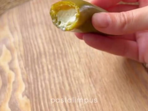 Cheese-stuffed pickled jalapeño peppers drizzled with olive oil on a platter