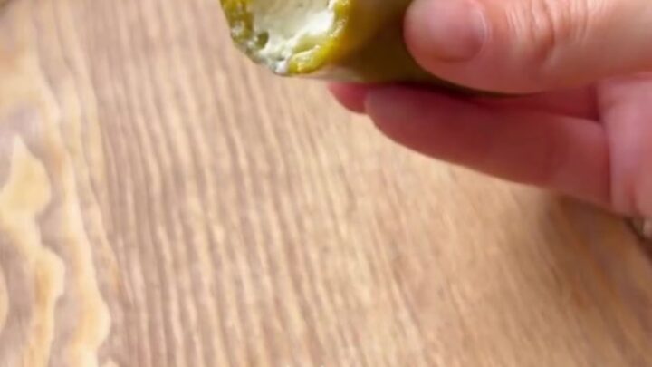 Cheese-stuffed pickled jalapeño peppers drizzled with olive oil on a platter