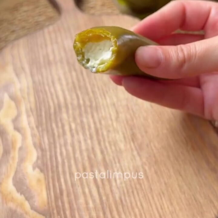 Cheese-stuffed pickled jalapeño peppers drizzled with olive oil on a platter