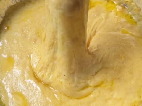 Black Sea kuymak in a copper pan with cheese pulling high on a fork