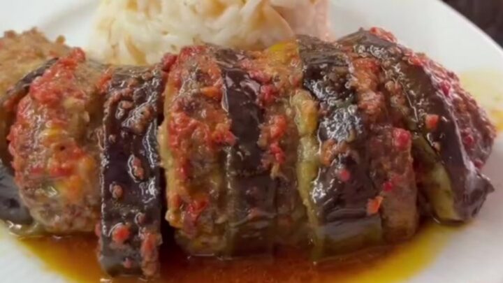 Bubbling baked eggplant kebab with meatballs in tomato glaze in a baking dish