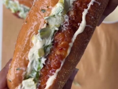 Cross-section of a hot honey Caesar chicken sandwich with crispy fried chicken, Caesar salad