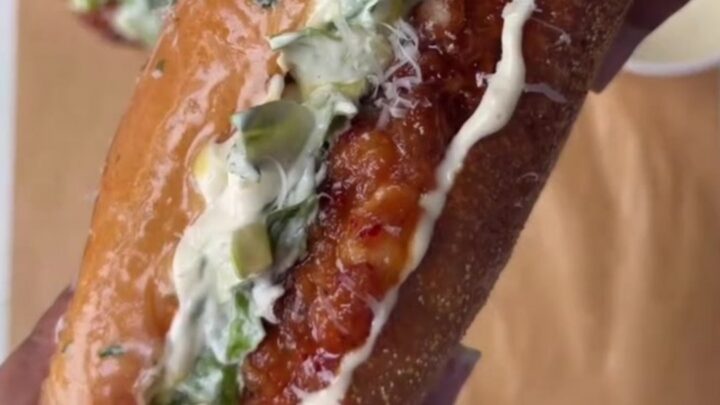 Cross-section of a hot honey Caesar chicken sandwich with crispy fried chicken, Caesar salad