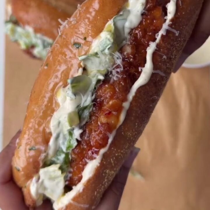 Cross-section of a hot honey Caesar chicken sandwich with crispy fried chicken, Caesar salad