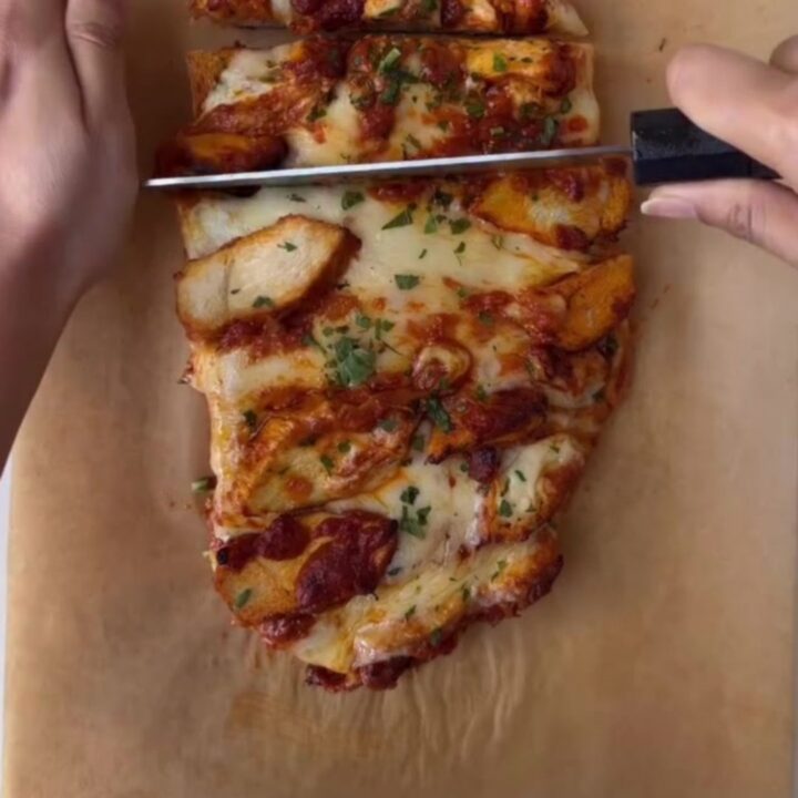 Sliced butter chicken cheesy bread bake with melted mozzarella and creamy sauce