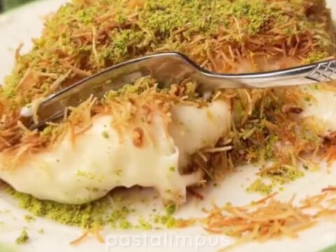 A square slice of kadayıf custard dessert on a plate, showing crispy golden top and creamy custard layer.