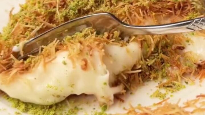 A square slice of kadayıf custard dessert on a plate, showing crispy golden top and creamy custard layer.