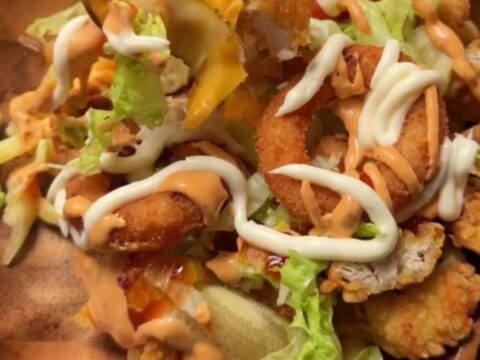 Cross-section of a crispy chicken fry dürüm wrap with melted cheese and fries