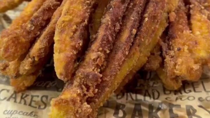 Golden crispy eggplant fan fries arranged on a plate with a bowl of garlic herb yogurt dip.
