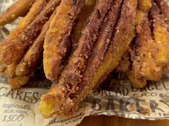 Golden crispy eggplant fan fries arranged on a plate with a bowl of garlic herb yogurt dip.