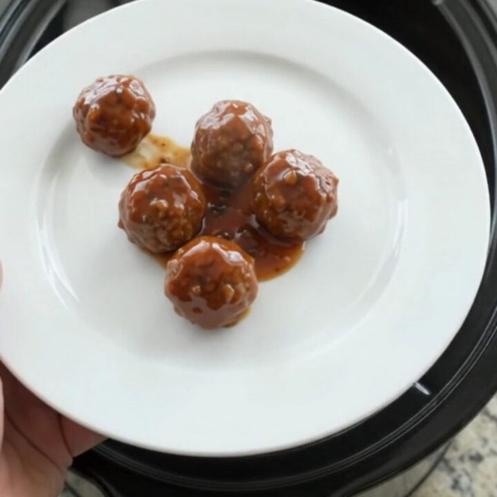 Glossy sweet and tangy cocktail meatballs in a slow cooker with a shiny mahogany glaze