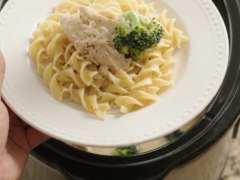 Slow cooker filled with creamy Parmesan broccoli chicken, ready to serve