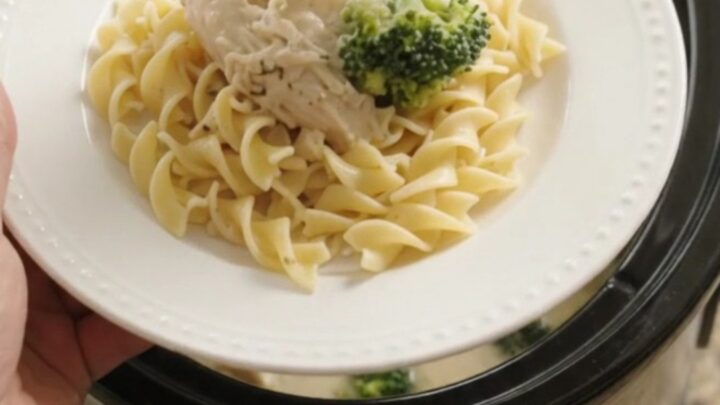 Slow cooker filled with creamy Parmesan broccoli chicken, ready to serve