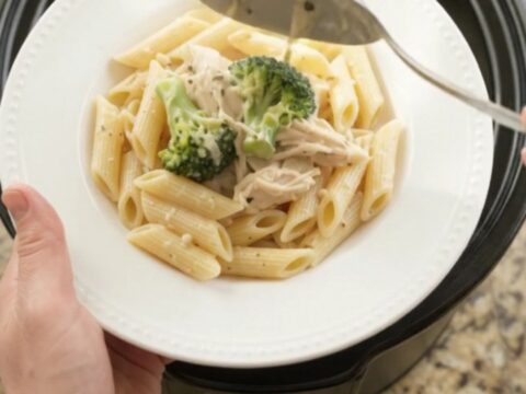 Creamy mozzarella broccoli chicken in a slow cooker with melted cheese and steam rising