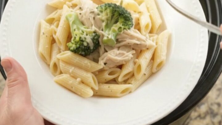 Creamy mozzarella broccoli chicken in a slow cooker with melted cheese and steam rising