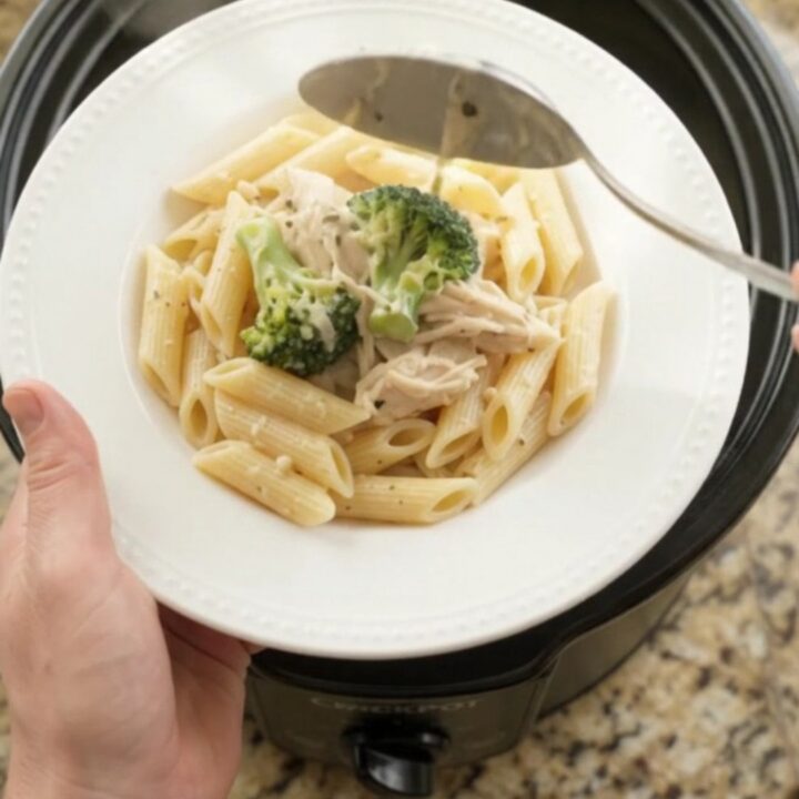 Creamy mozzarella broccoli chicken in a slow cooker with melted cheese and steam rising