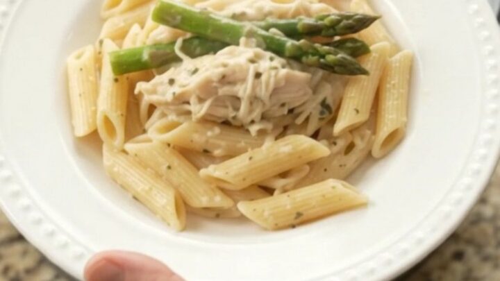 Creamy mozzarella asparagus chicken in a slow cooker, with shredded chicken and asparagus in a rich sauce.