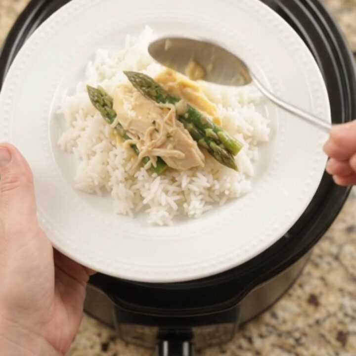 Creamy cheddar asparagus chicken in a slow cooker, with shredded chicken and asparagus in a rich golden sauce.