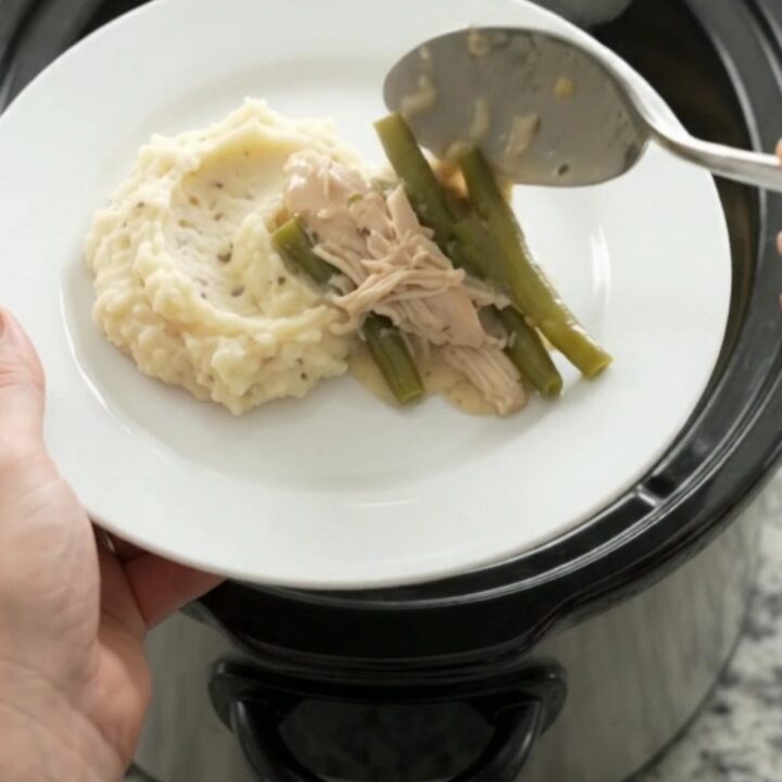 Creamy Swiss green bean chicken in a slow cooker, with melted cheese and tender chicken pieces