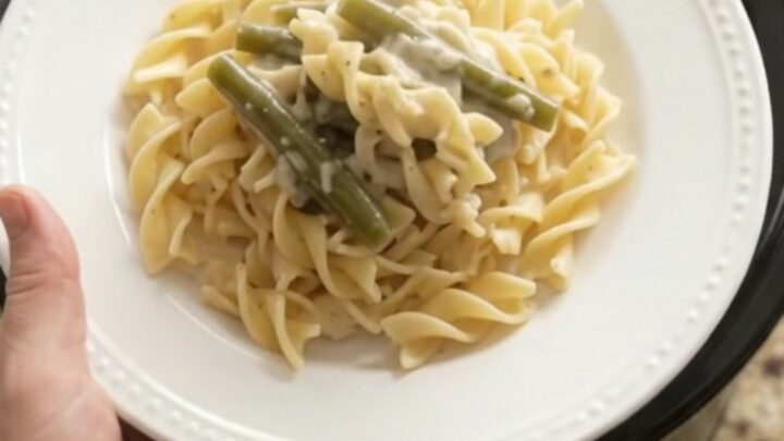 Creamy Parmesan green bean chicken in a slow cooker, with shredded chicken and green beans in a velvety sauce