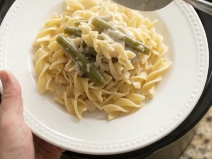 Creamy Parmesan green bean chicken in a slow cooker, with shredded chicken and green beans in a velvety sauce