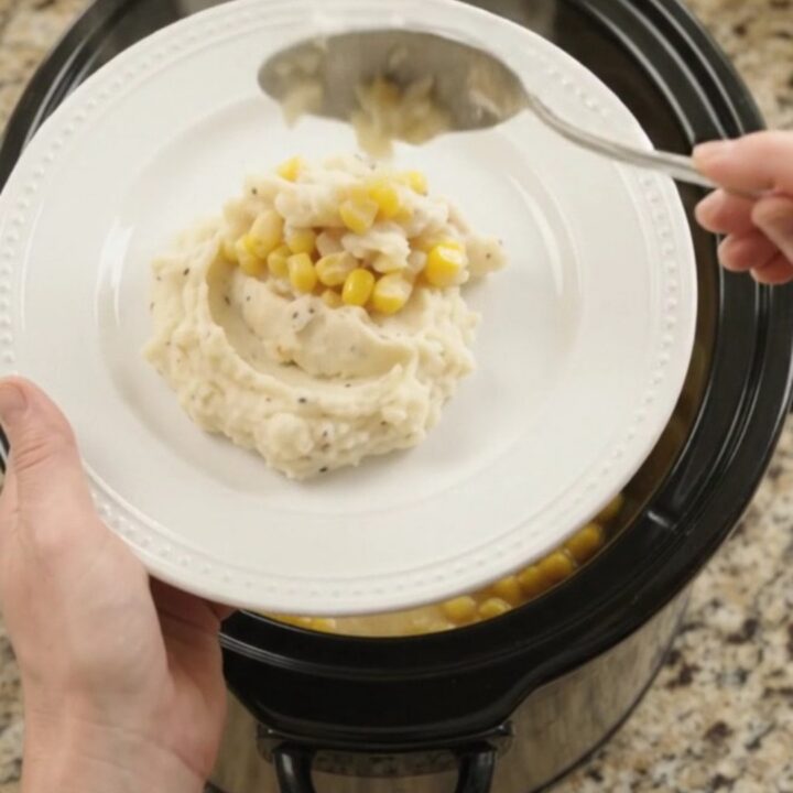 Creamy Swiss sweet corn chicken in a slow cooker with shredded chicken and melted cheese