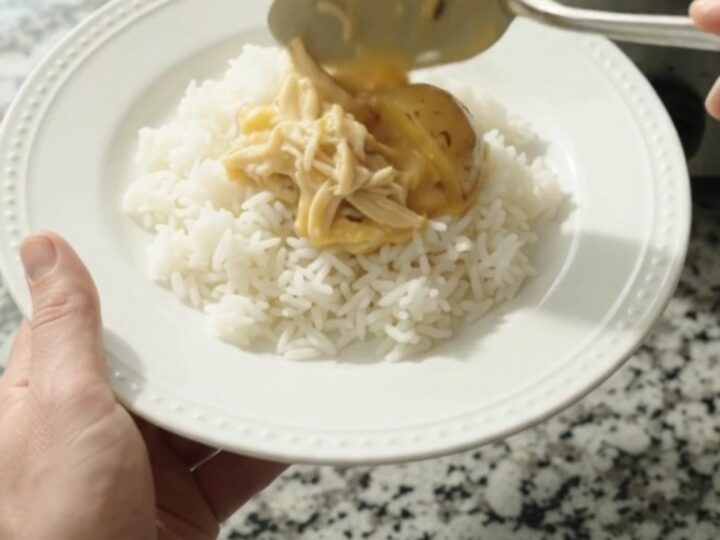 Slow cooker creamy cheddar chicken and baby potatoes in a rich sauce, topped with melted cheddar and butter.