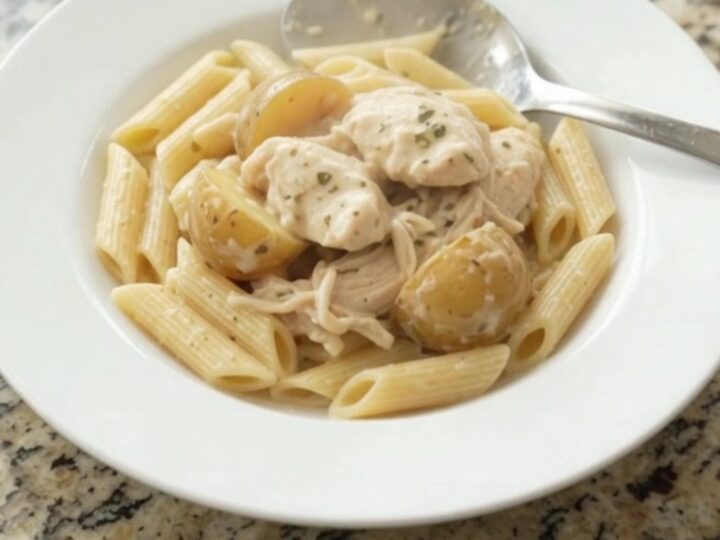 Creamy mozzarella chicken and baby potatoes in a slow cooker, topped with melted cheese and garlic butter.