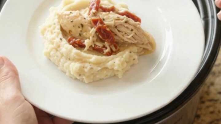 Slow cooker creamy Swiss sun-dried tomato chicken with bubbling sauce and melted cheese