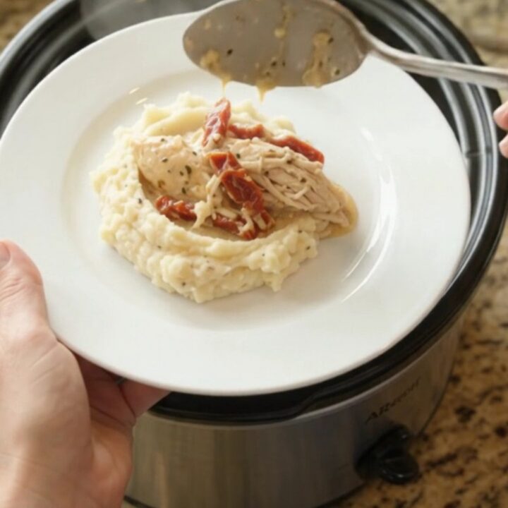 Slow cooker creamy Swiss sun-dried tomato chicken with bubbling sauce and melted cheese