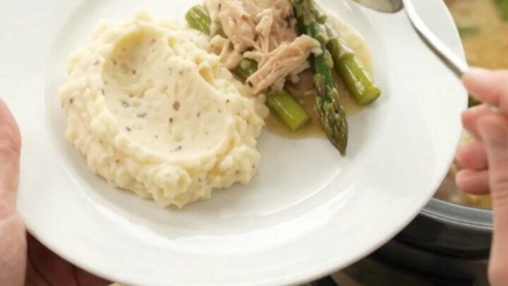 Slow cooker creamy Swiss asparagus chicken thighs with sauce in the crockpot