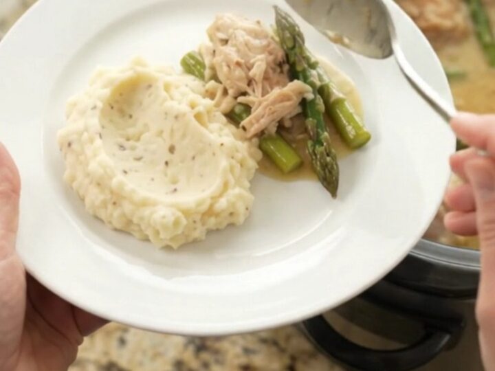 Slow cooker creamy Swiss asparagus chicken thighs with sauce in the crockpot