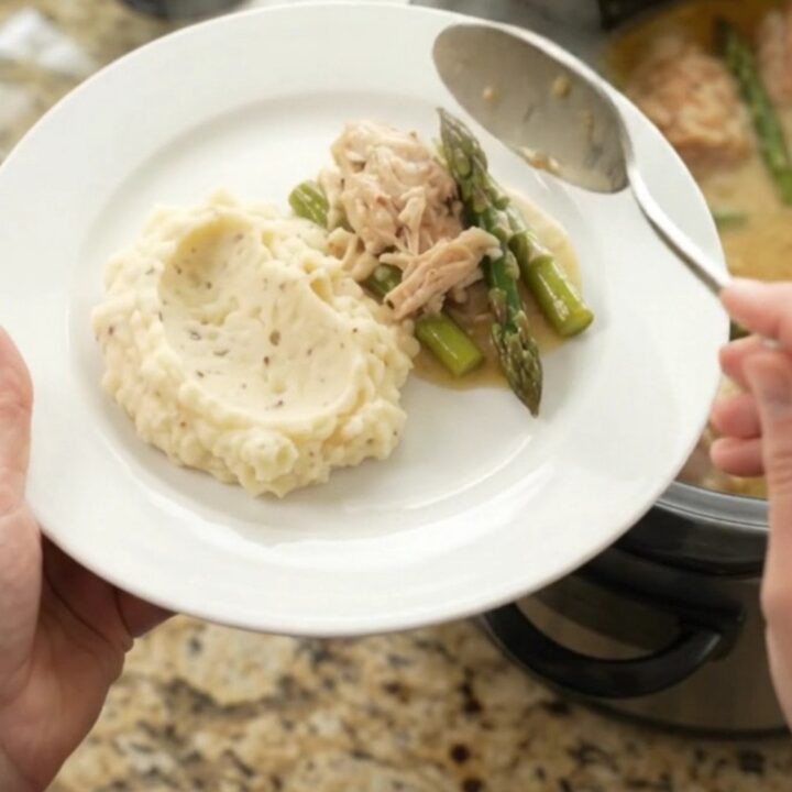 Slow cooker creamy Swiss asparagus chicken thighs with sauce in the crockpot