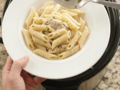Slow cooker filled with creamy mozzarella chicken and asparagus, bubbling and steaming