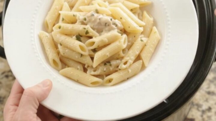 Slow cooker filled with creamy mozzarella chicken and asparagus, bubbling and steaming