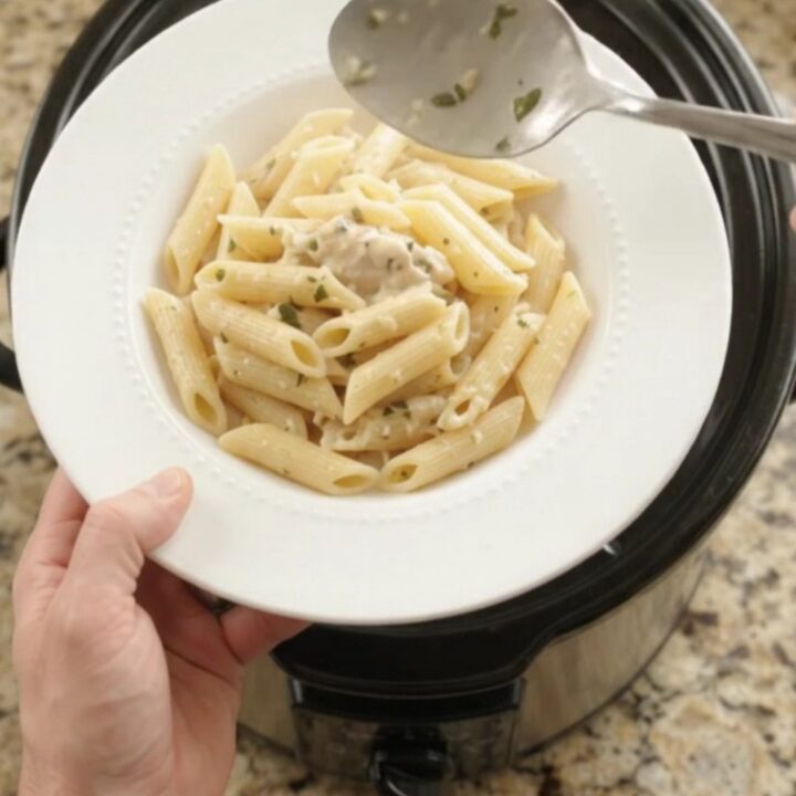 Slow cooker filled with creamy mozzarella chicken and asparagus, bubbling and steaming