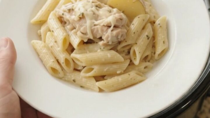 Slow cooker full of creamy mozzarella chicken thighs and baby potatoes with a rich, bubbling sauce