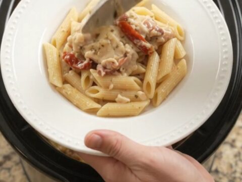 Slow cooker full of creamy mozzarella sun-dried tomato chicken thighs, bubbling with cheese and herbs