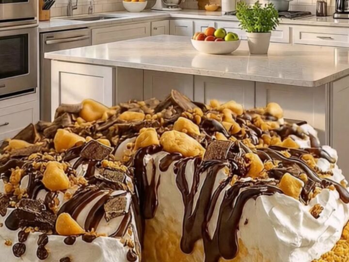 A towering slice of no-bake peanut butter pie with chocolate drizzle on a dark platter.
