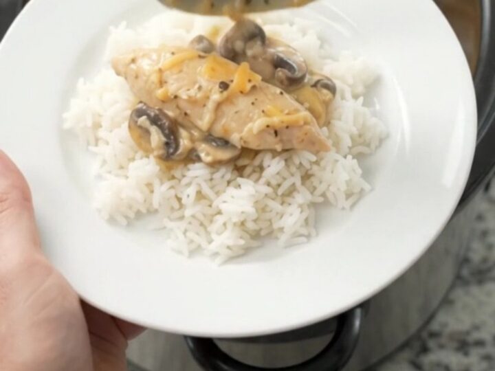 Golden Cheddar Mushroom Chicken Tenders bubbling in a slow cooker, with creamy sauce and mushrooms visible.
