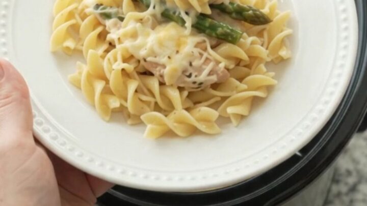 Slow cooker filled with creamy Parmesan asparagus chicken tenders, ready to serve