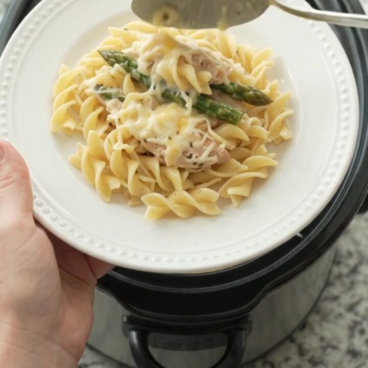Slow cooker filled with creamy Parmesan asparagus chicken tenders, ready to serve