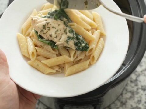 Creamy crockpot chicken tenders with spinach and artichokes, topped with melted mozzarella and garlic butter.