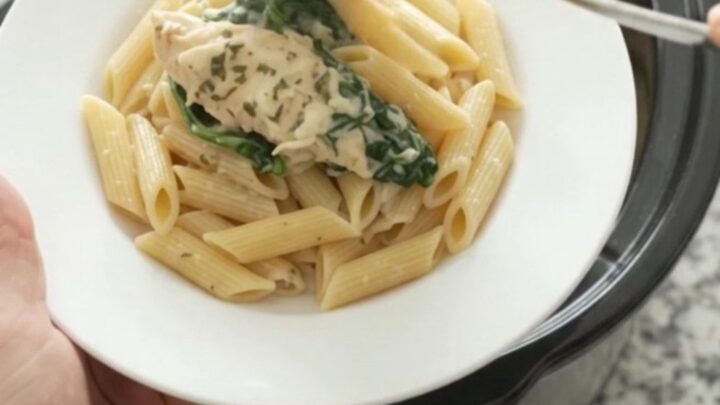 Creamy crockpot chicken tenders with spinach and artichokes, topped with melted mozzarella and garlic butter.